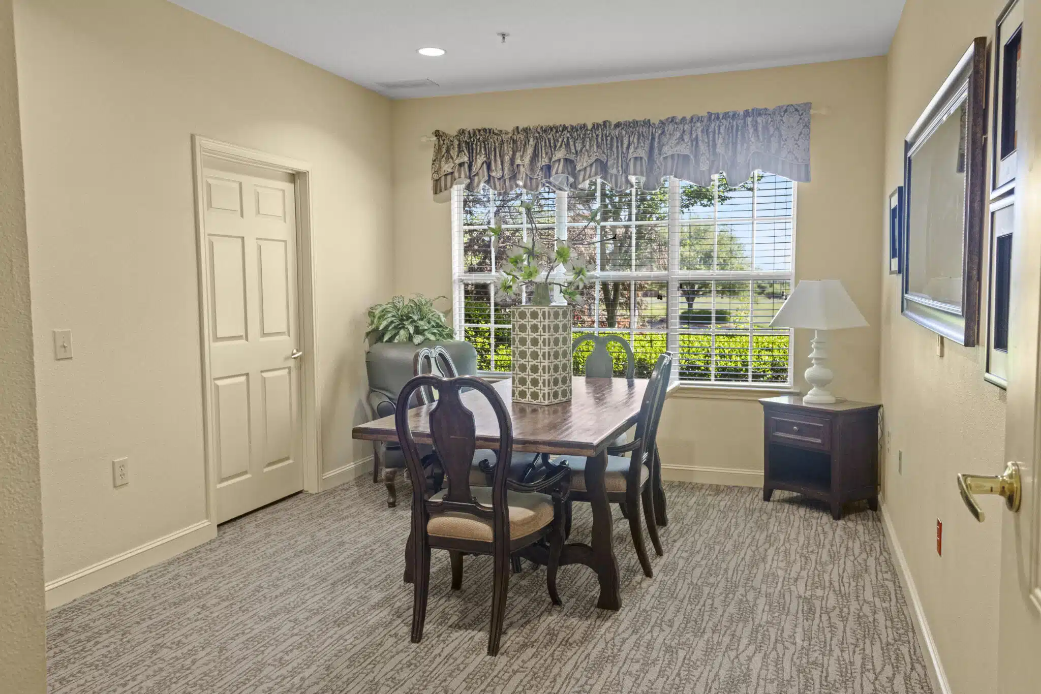Lounge/Loft area with table and chairs that are sitting in front of a window with a view of the outside.
