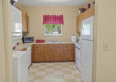 Photo of resident's kitchen with an L-shaped countertop. Appliances shown are Clothes washer and dryer, dishwashe, microwave oven, stove/oven, and refrigerator.